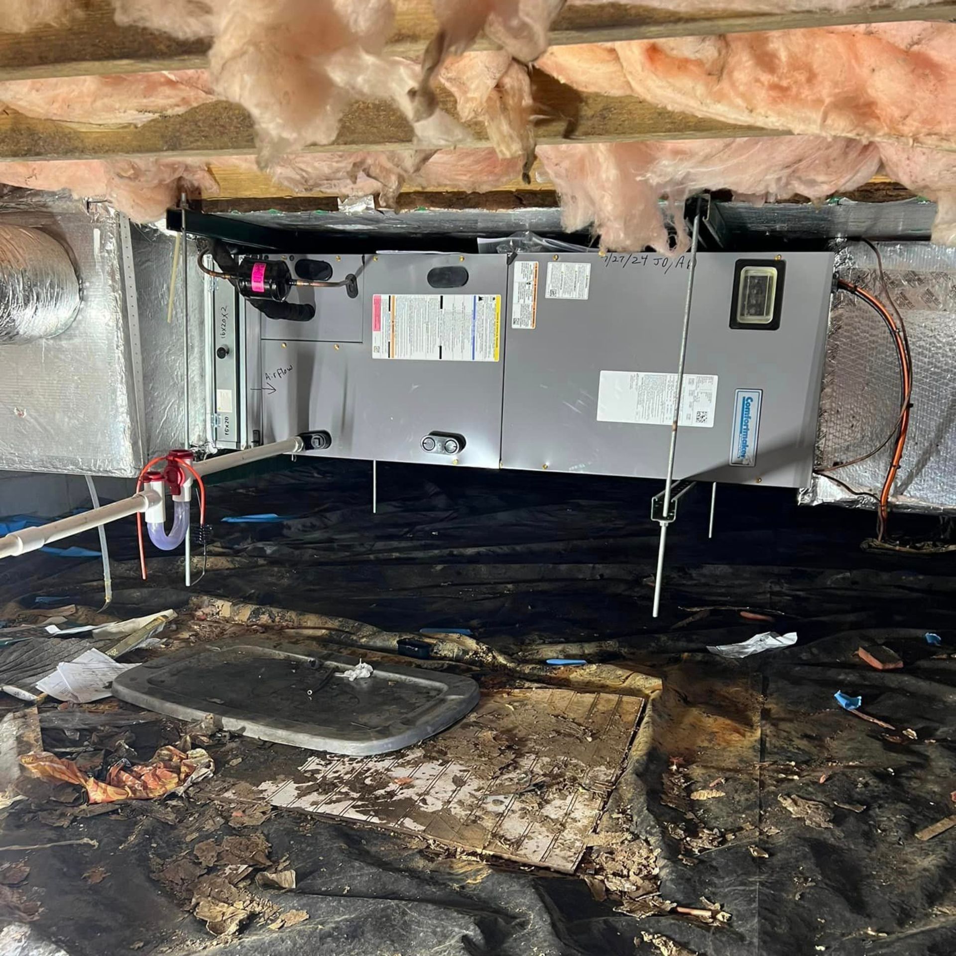 An air conditioner is sitting under a ceiling in a room.