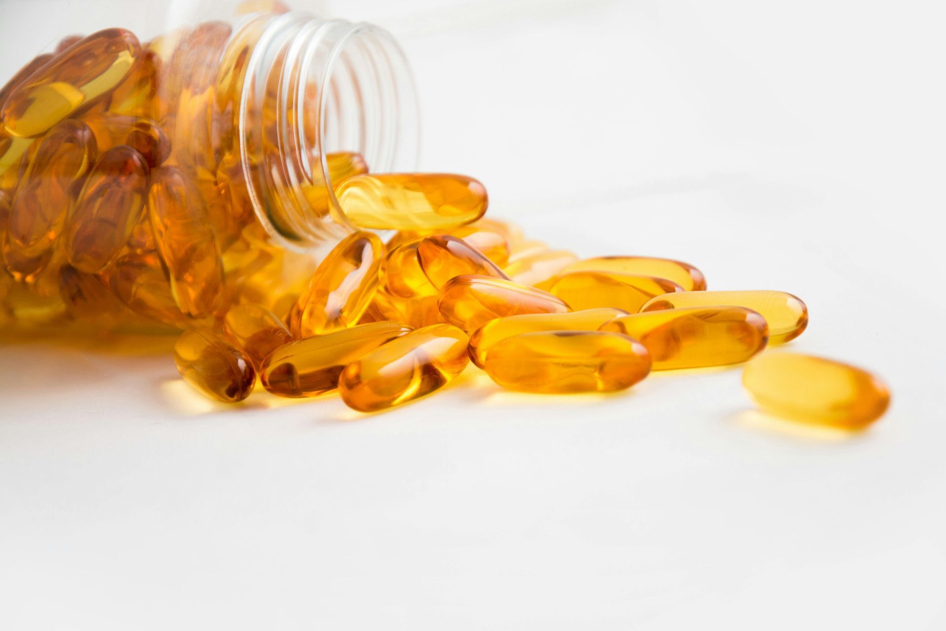 A bottle of pills is spilling out onto a table