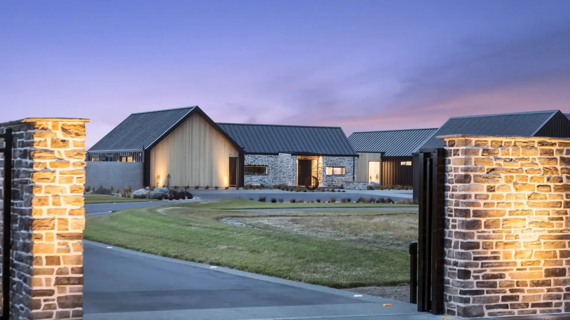 Stone houses at dusk with illuminated brick entrance.