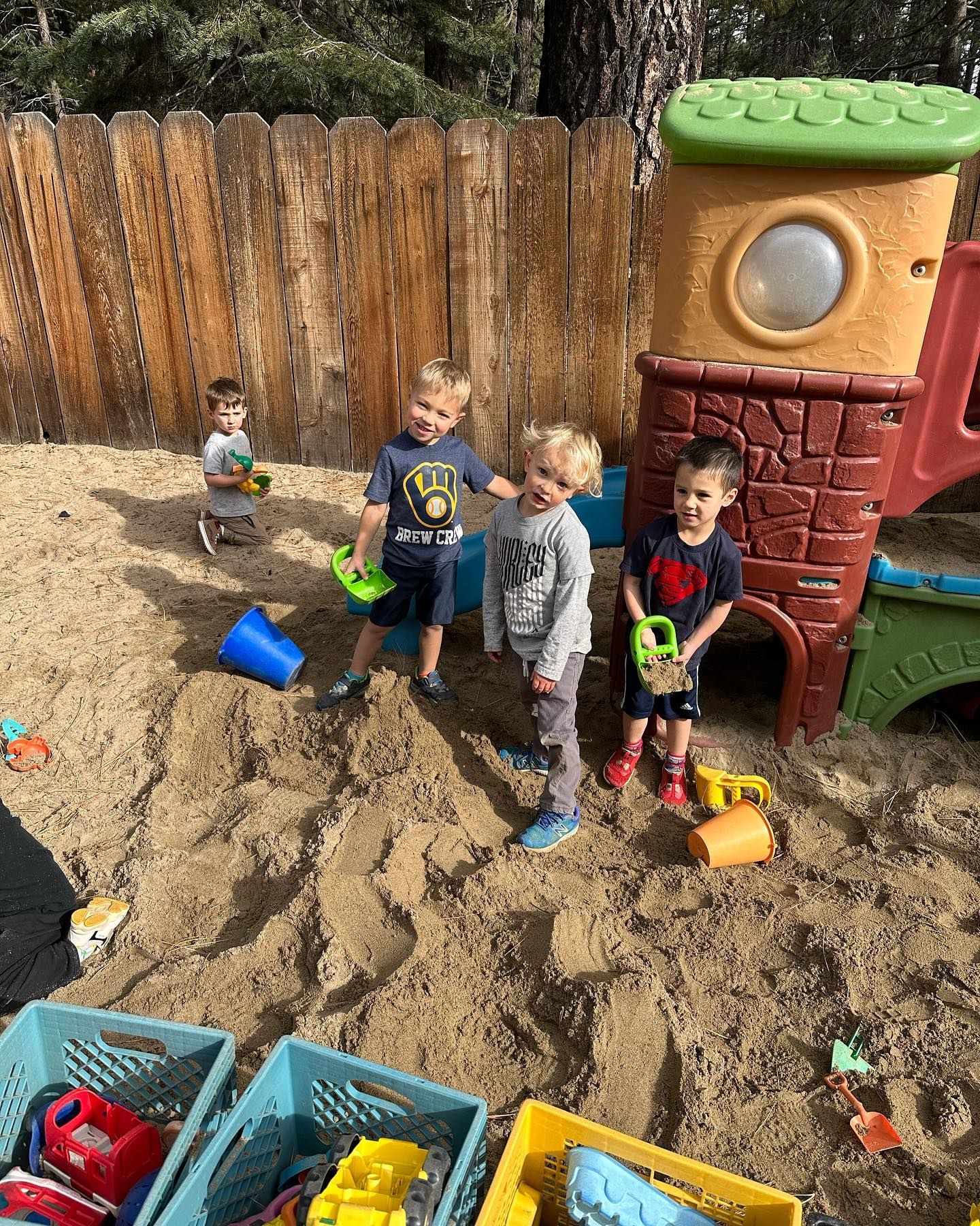 A group of young boys are playing in a sandbox.