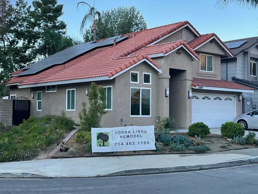 House with red tile roof, solar panels, and a sign for Loma Linda Remodel.