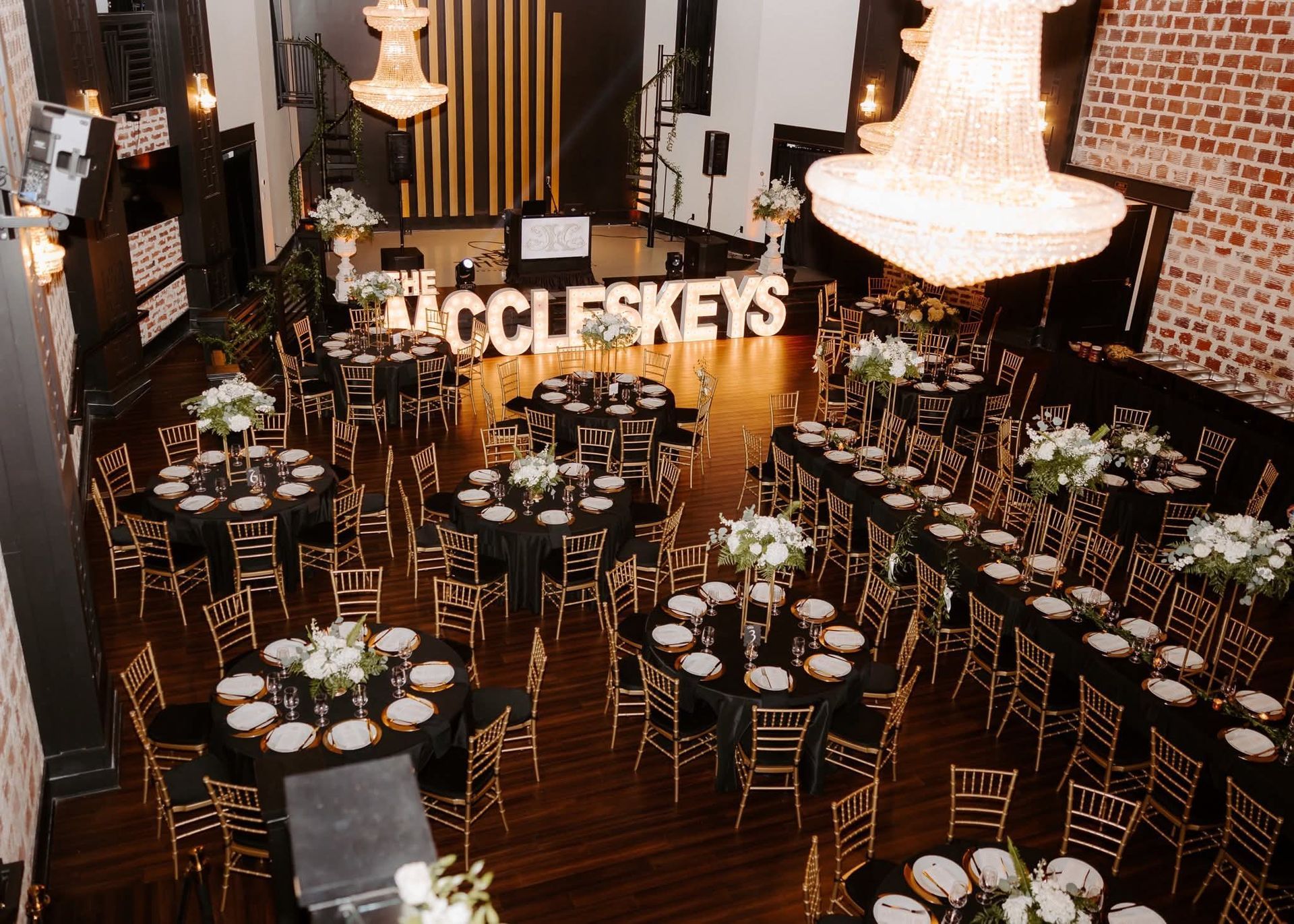 black and gold themed wedding reception with large marquee of couple's name