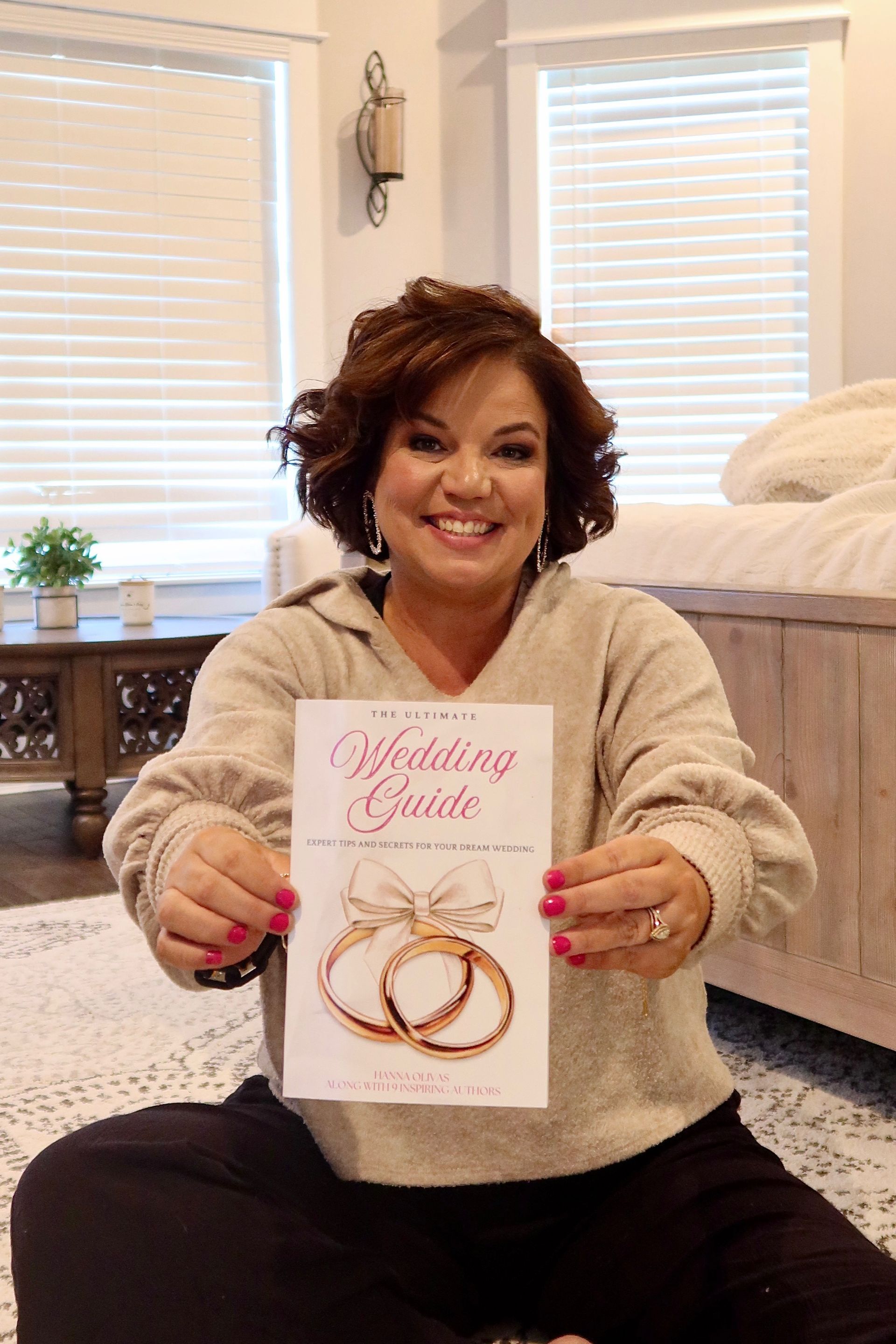Callie Carr holding copy of The Ultimate Wedding Guide book