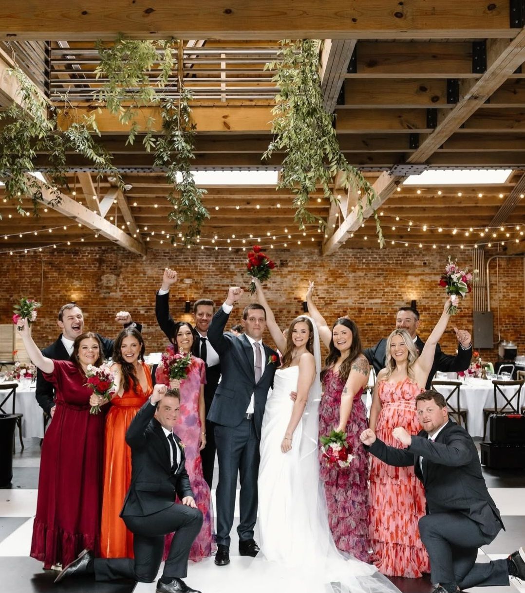 bride and groom cheering with wedding party