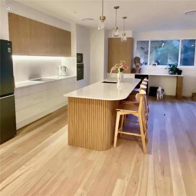 A Kitchen With a Large Island and Stools — Kenross Kitchens In Avoca Beach, NSW