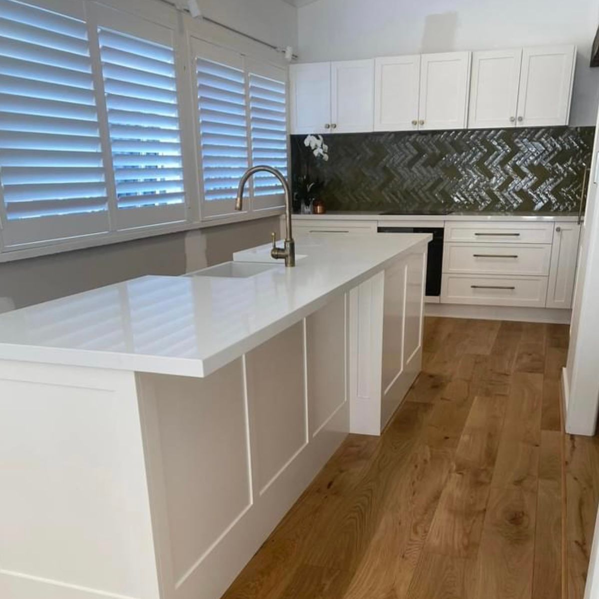 A Kitchen With White Cabinets and a Gas Stove Top — Kenross Kitchens In Erina, NSW