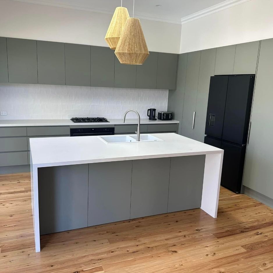 A Kitchen With Black Cabinets and a Stove Top Oven — Kenross Kitchens In Erina, NSW