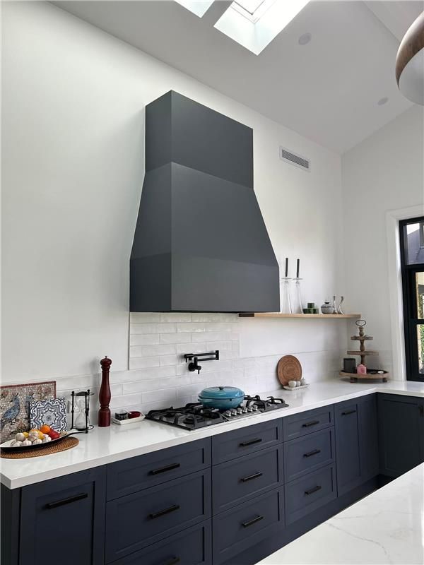 A Kitchen With Blue Cabinets and White Counter Tops — Kenross Kitchens In Terrigal, NSW