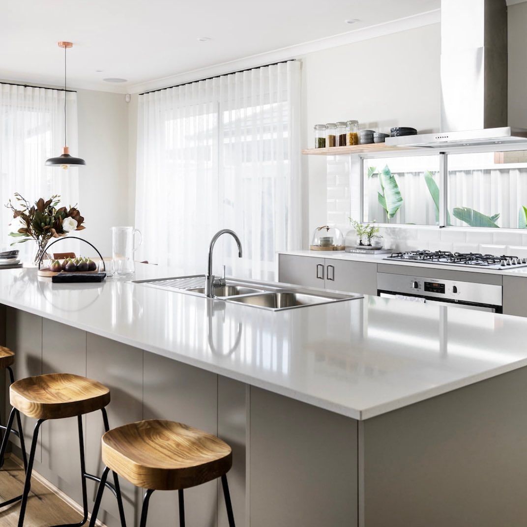 A Kitchen With a Large Island, Sink, Stove and Stools — Kenross Kitchens In Erina, NSW