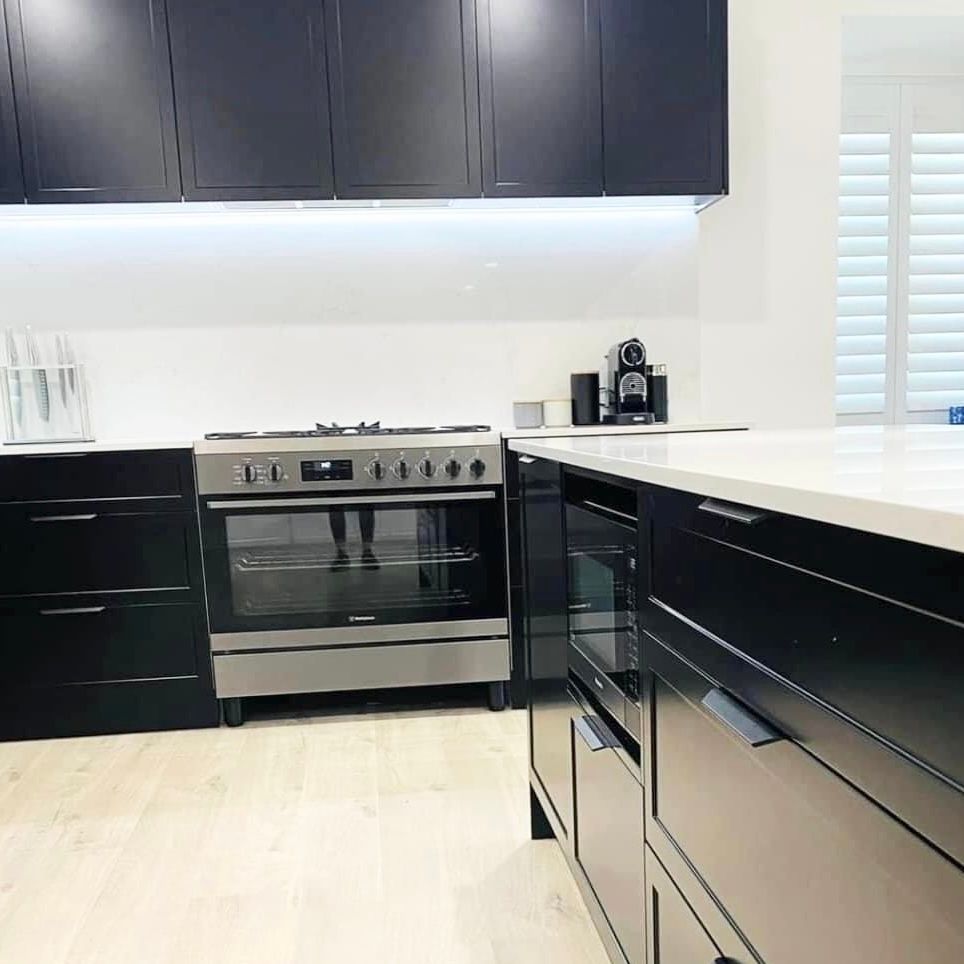 A kitchen with a large island and stools — Kenross Kitchens In Erina, NSW