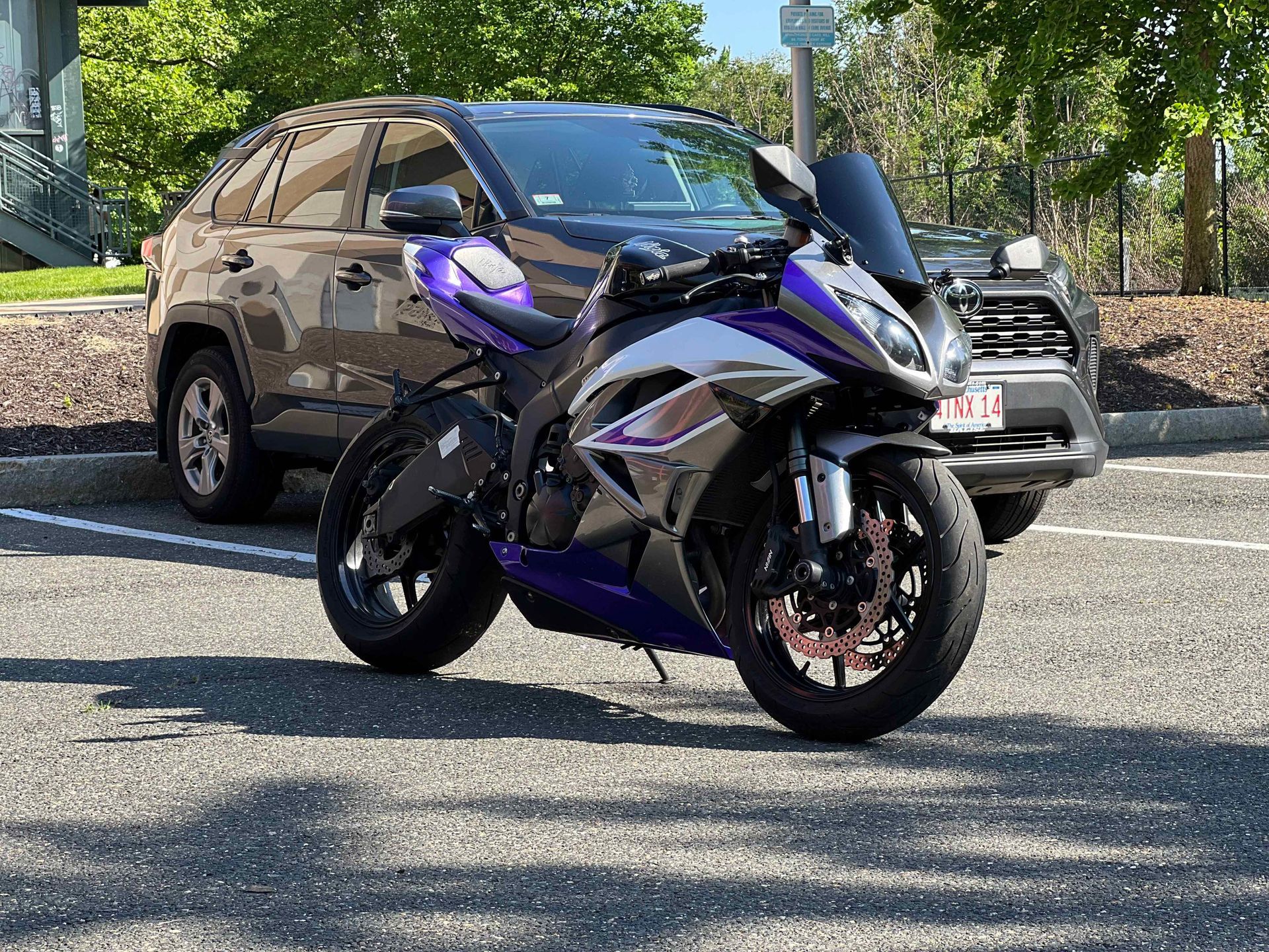 Orange Audi coupe parked under bridge, sunset lighting.