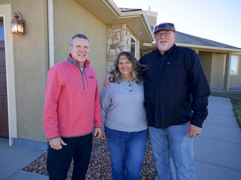 People signing documents at a table with a gavel, possibly in a legal setting.