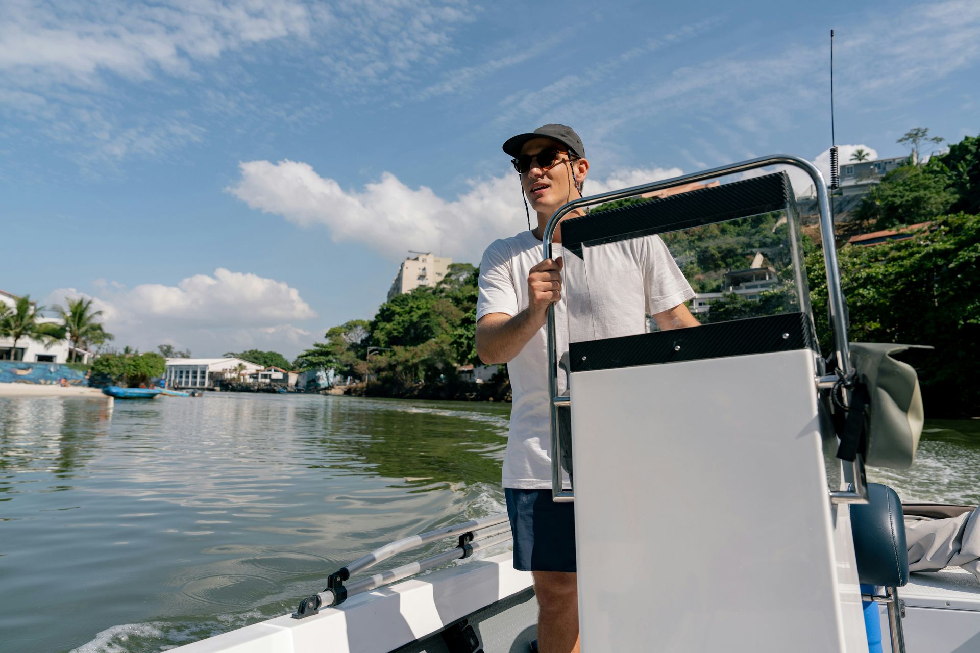 Hand with gold wedding ring on a wooden surface, blurred outdoor background.