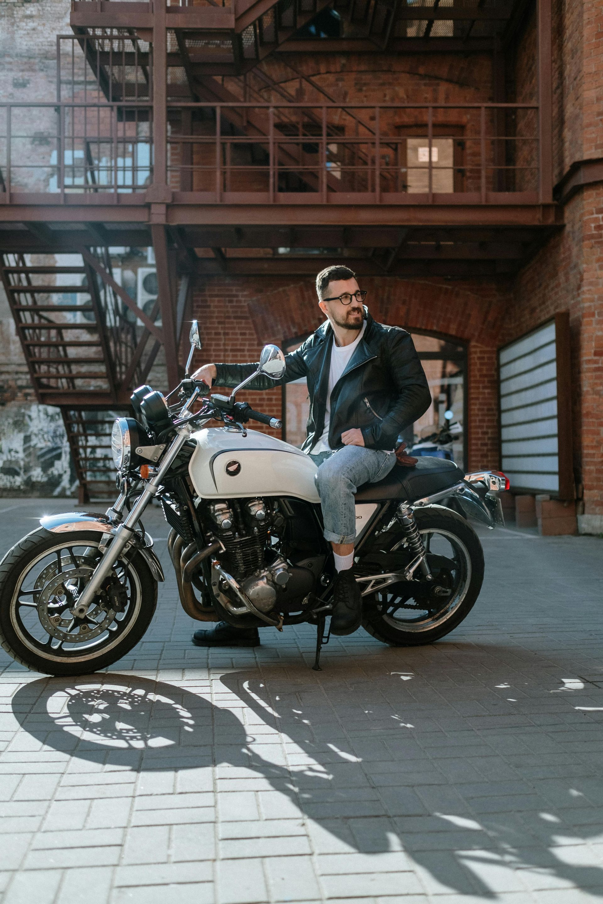 Man in gray hoodie consoles woman in white shirt on a couch.