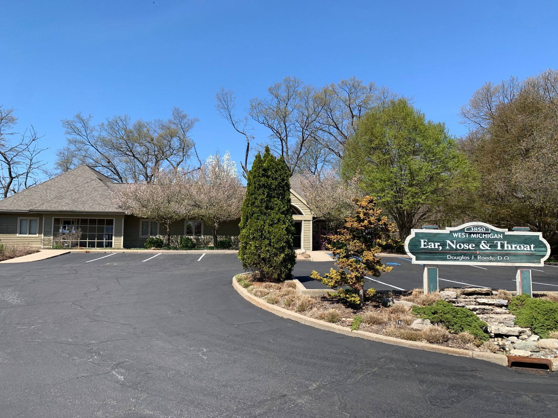 A group of people standing in front of a sign that says west michigan ear nose & throat