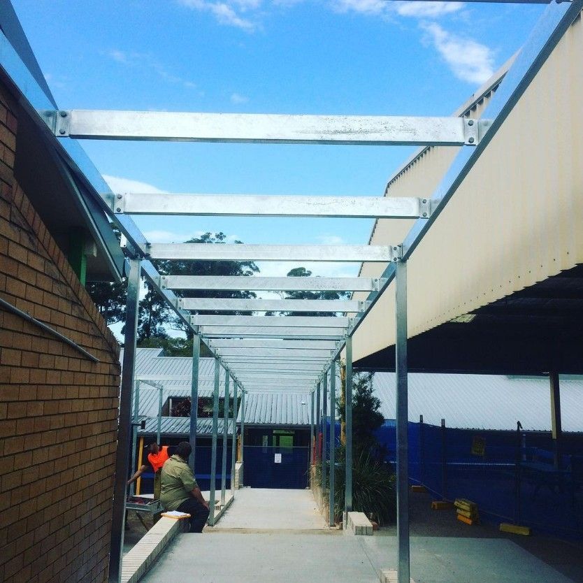 A Man Sits on a Bench Under a Covered Walkway — Barry Smith Engineering Pty Ltd in Coffs Harbour, NSW