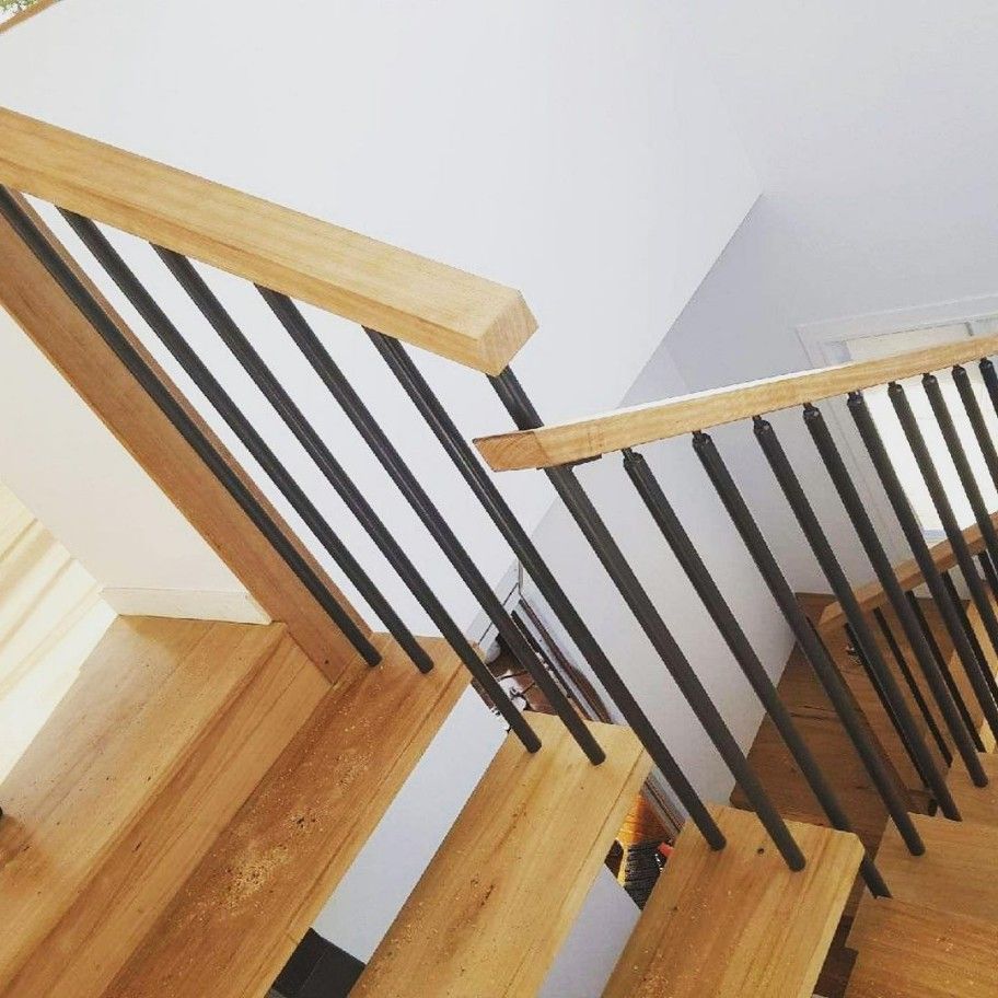 A Wooden Staircase With a Black Metal Railing — Barry Smith Engineering Pty Ltd in Coffs Harbour, NSW