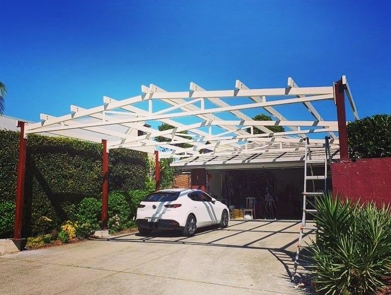 A White Car is Parked Under a Wooden Structure — Barry Smith Engineering Pty Ltd in Coffs Harbour, NSW
