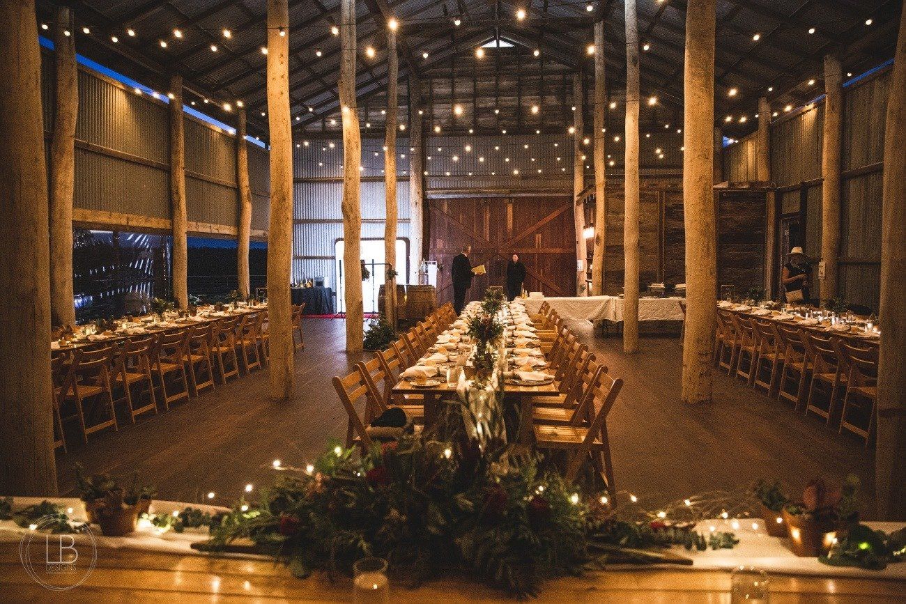 A large room with tables and chairs set up for a wedding reception.