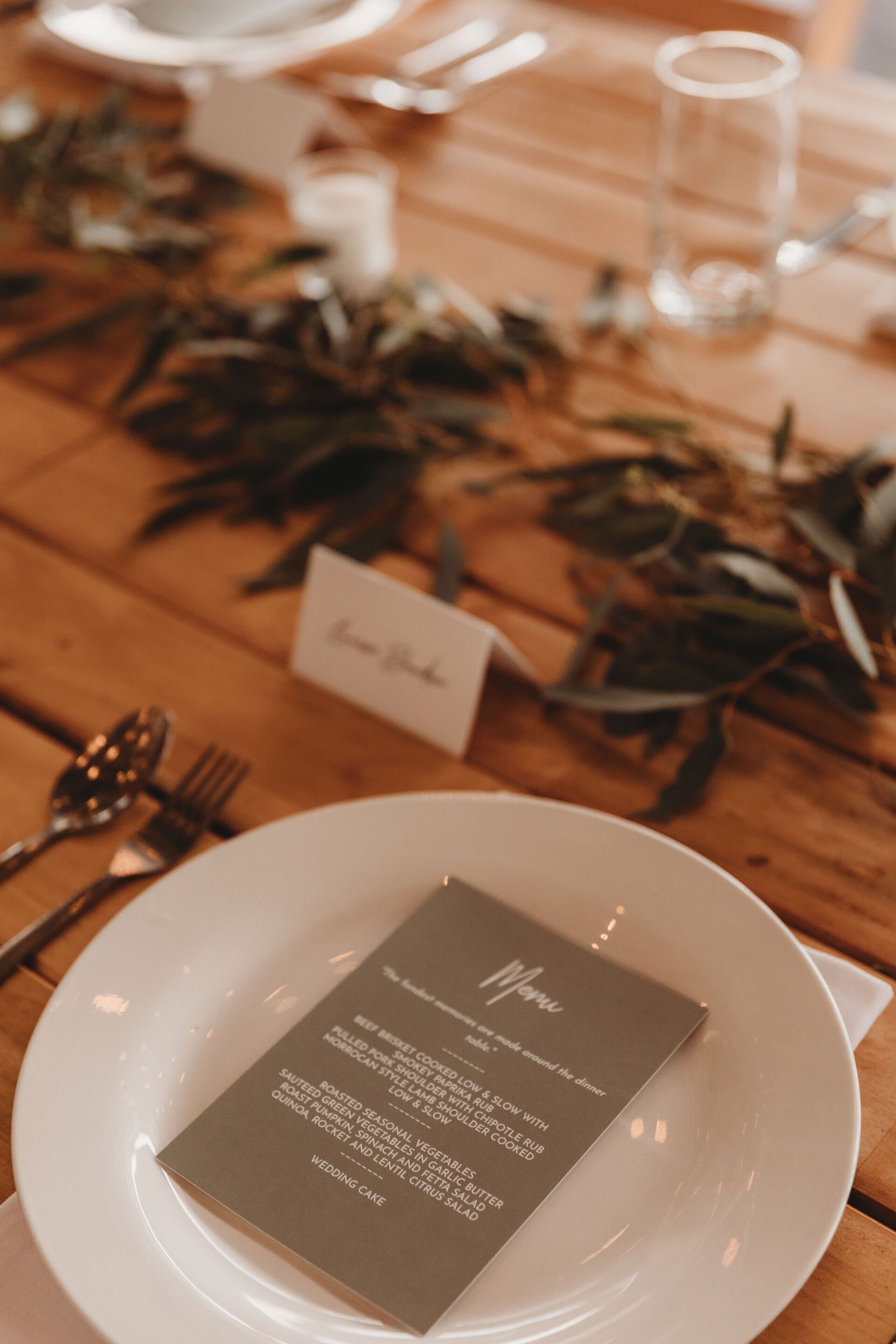 A white plate with a menu on it is sitting on a wooden table.