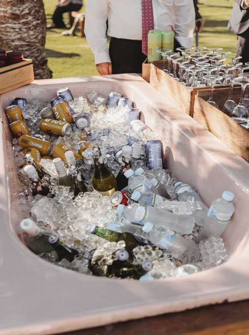 A bathtub filled with ice and beer cans and bottles.