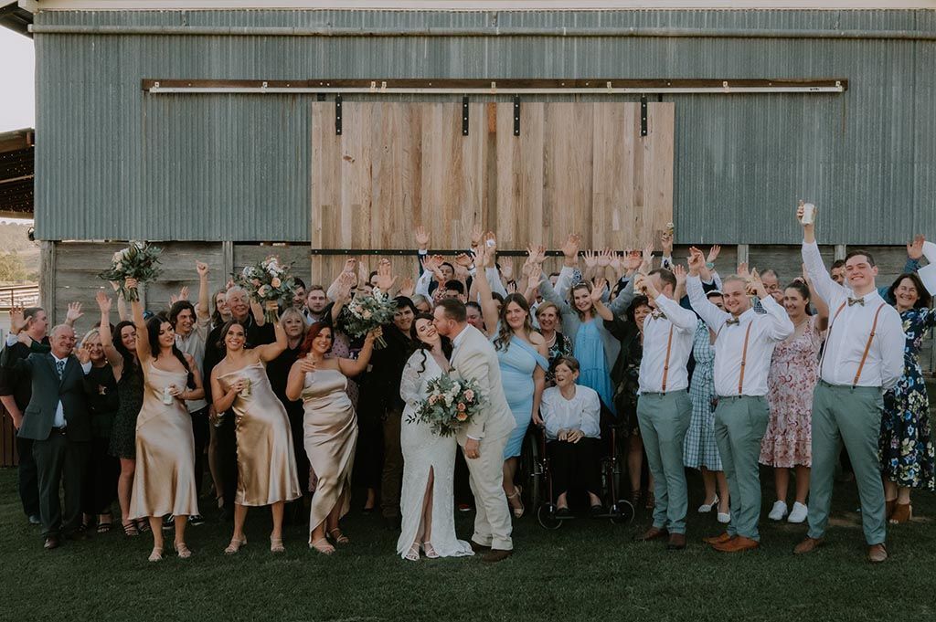 A large group of people are posing for a picture at a wedding.