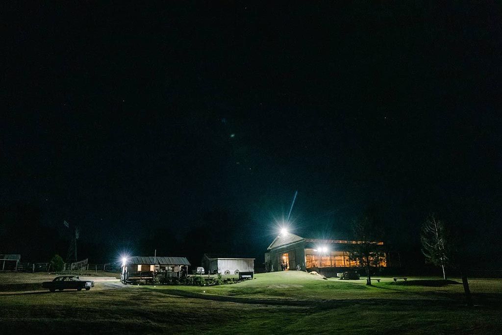 There is a house in the middle of a field at night.