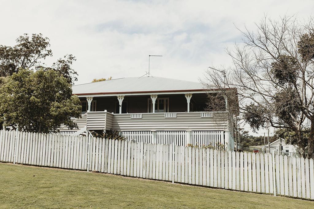 A large white house with a white picket fence in front of it.
