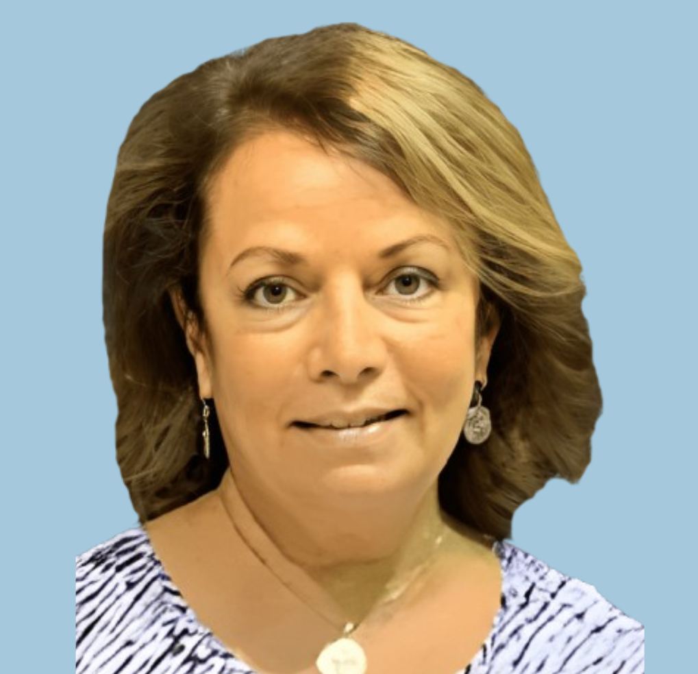 A woman wearing a necklace and earrings smiles for the camera