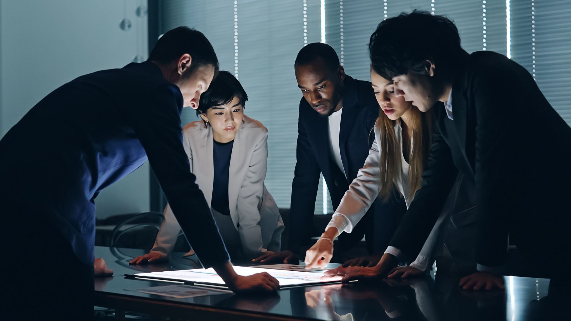 A group of people are standing around a table looking at a map.