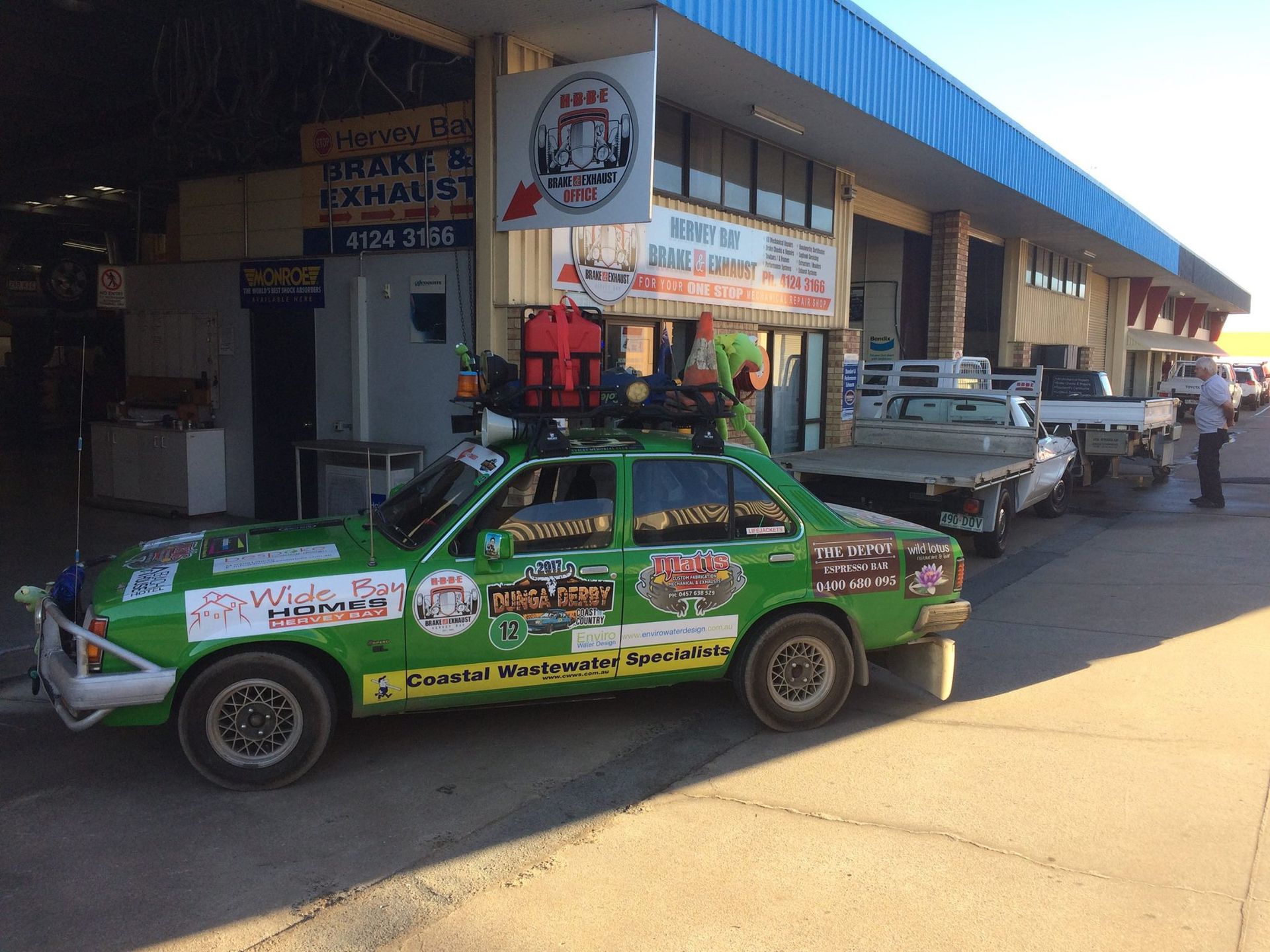 Green Racing Car with Stickers in Front of the Garage — Car Tuning in Pialba, QLD