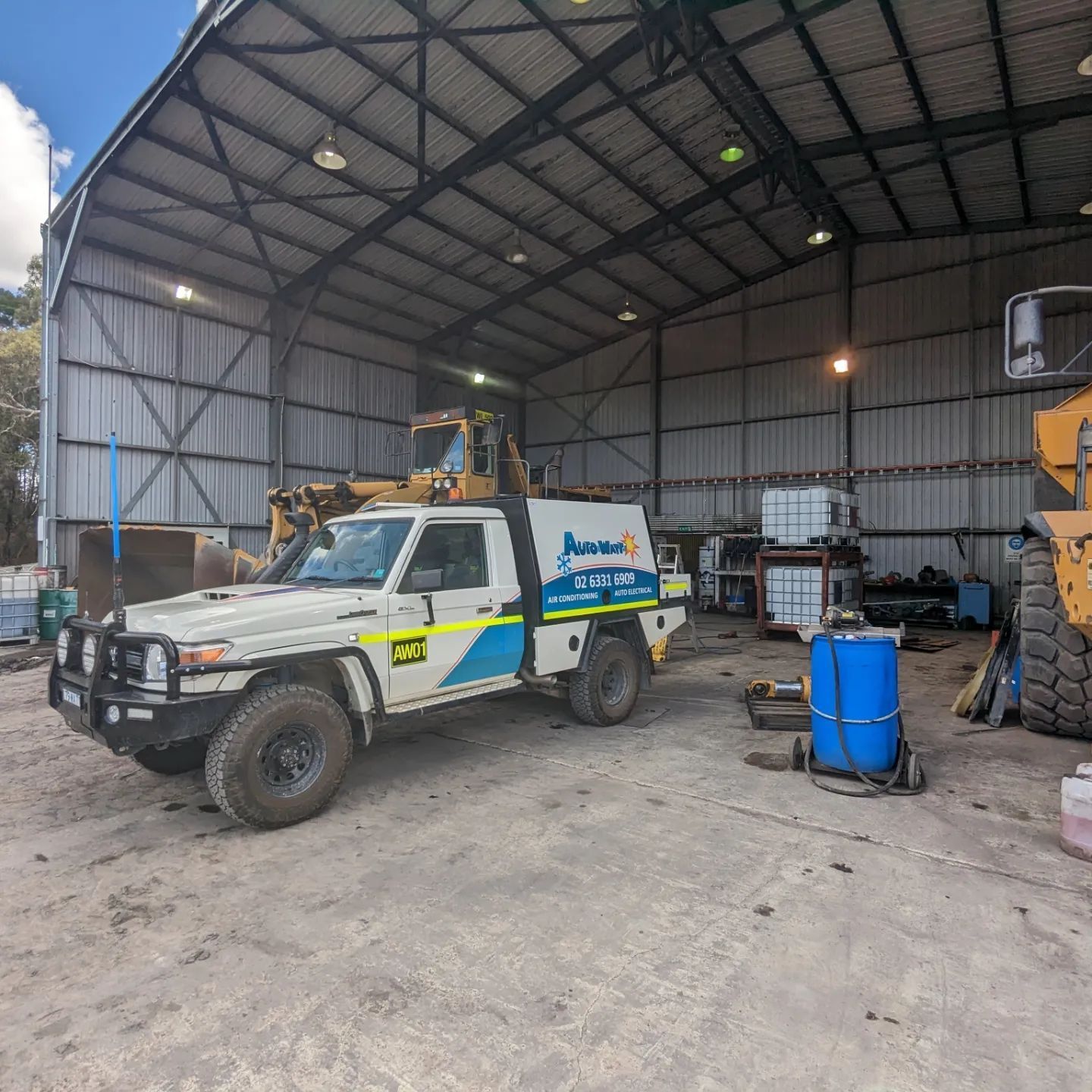 A White Utility Vehicle Inside a Large, Open-sided Metal Shed — Auto Watt in Kelso, NSW