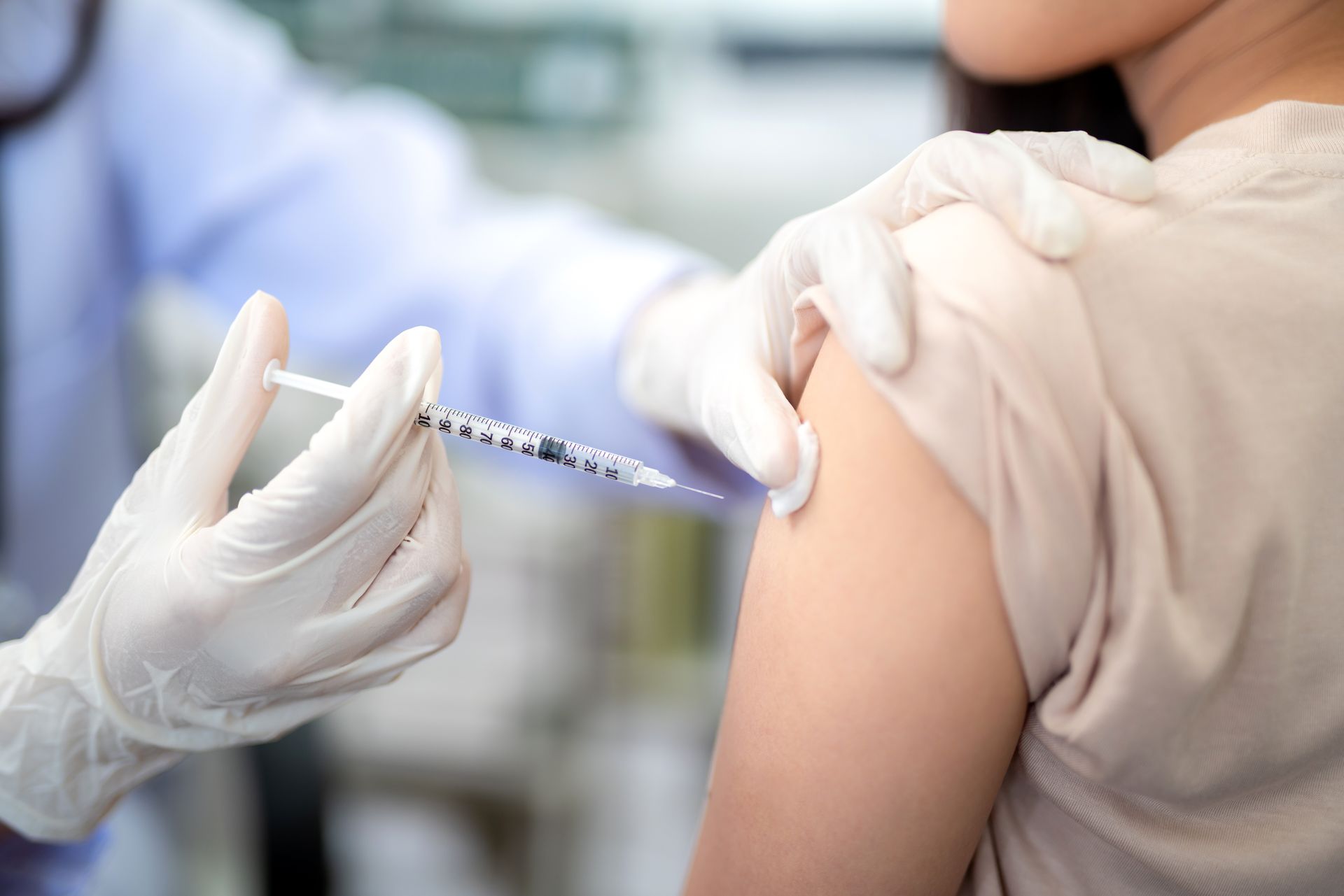 Doctor administering a vaccine injection in a patient's upper arm.