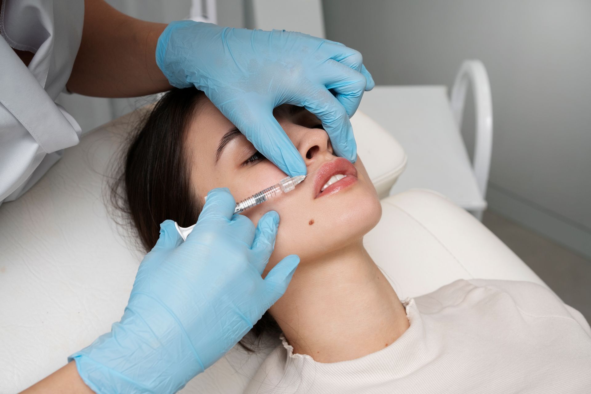 Person receiving lip filler injections from a medical professional.