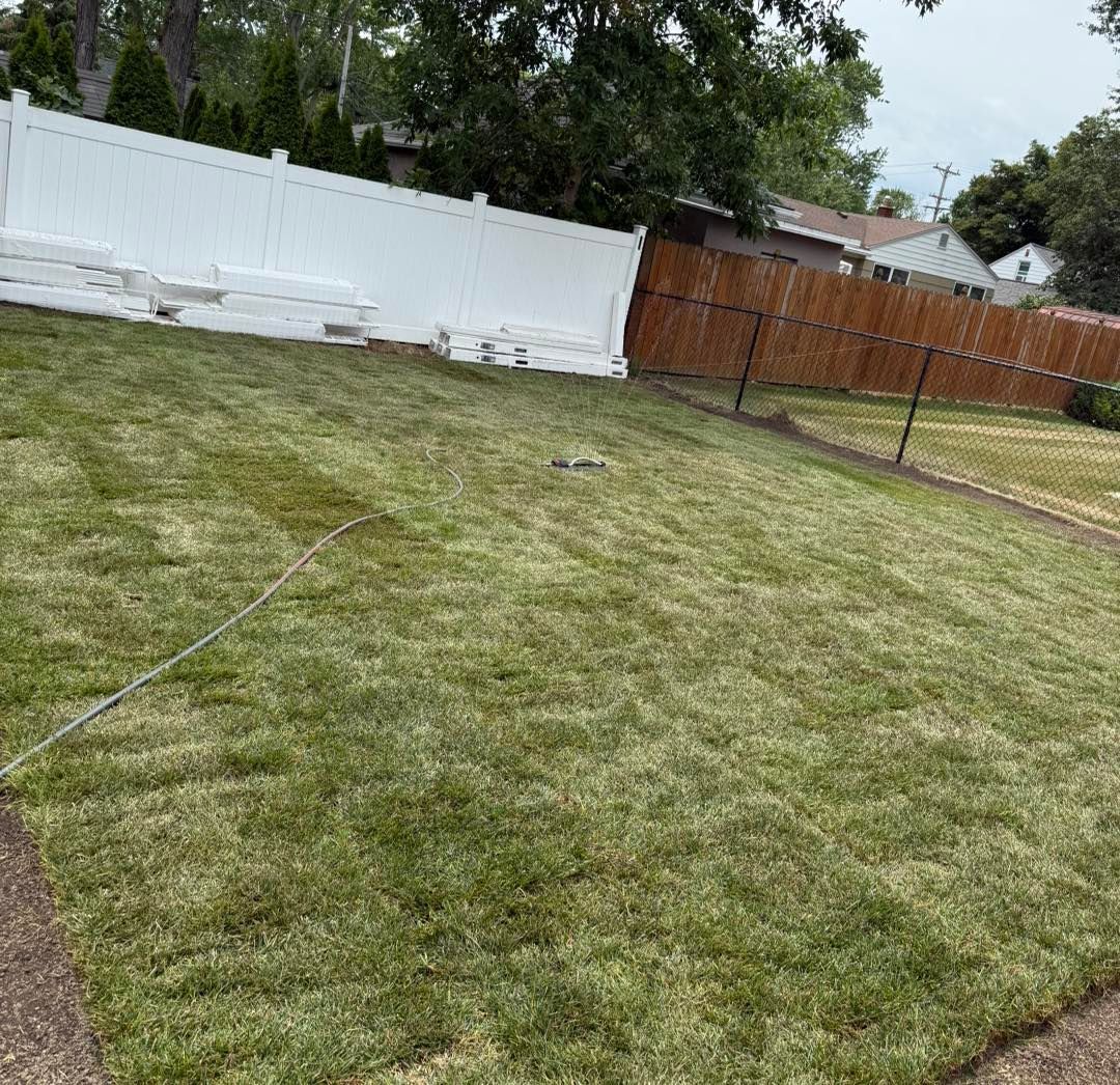 Lush green lawn with white and brown fences. Sod Installation