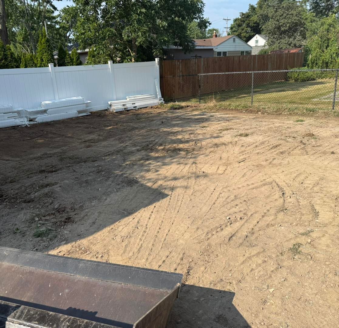Dirt lot with white and wood fences, a sunny day.