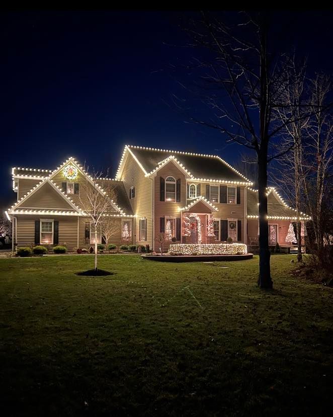 House decorated with white Christmas lights against a dark night sky.