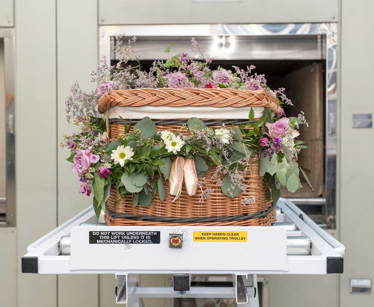 A wicker basket filled with flowers is sitting on top of a conveyor belt.