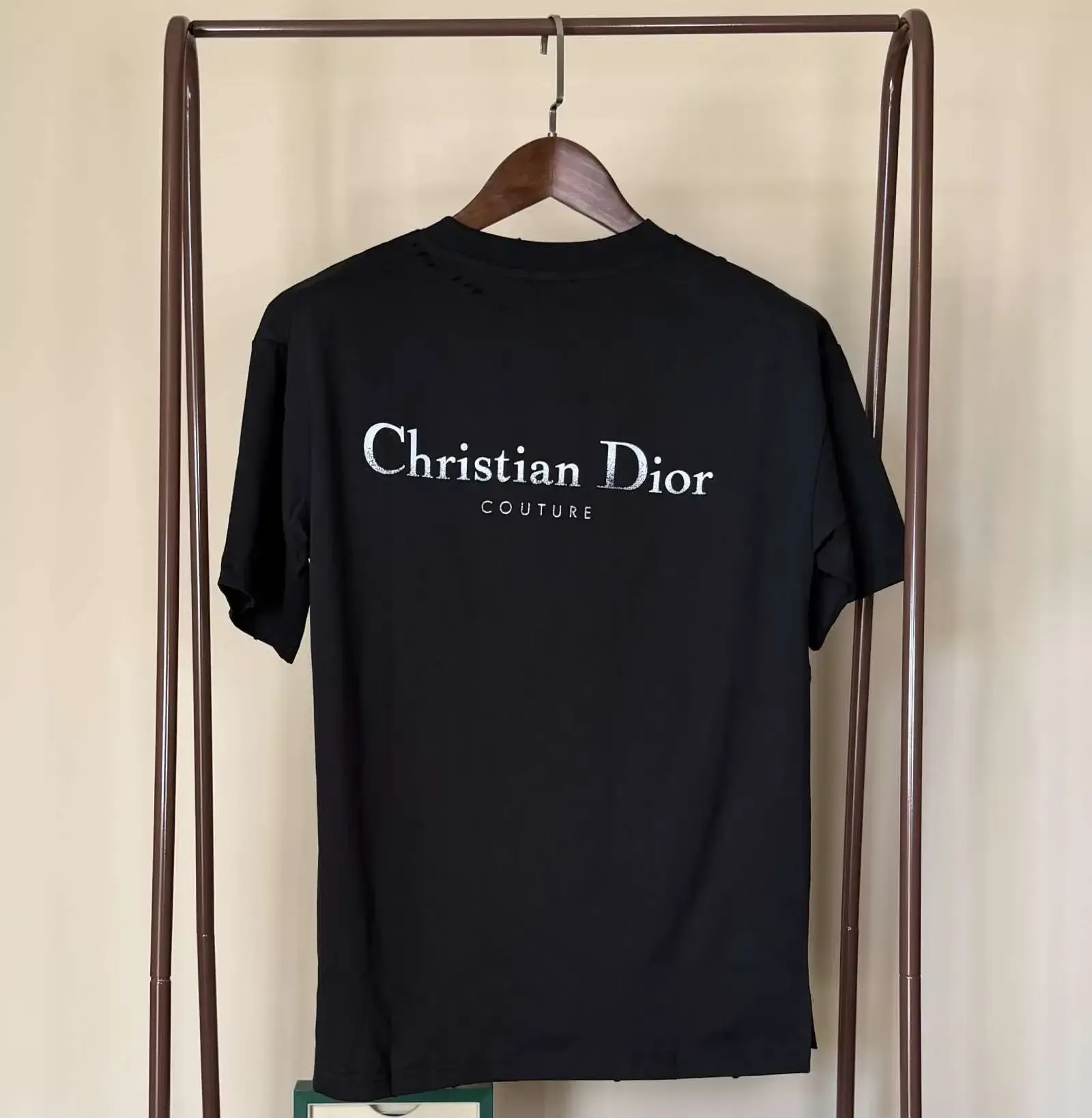 Black DXR t-shirt with logo on a brown hanger, displayed on a clothing rack.