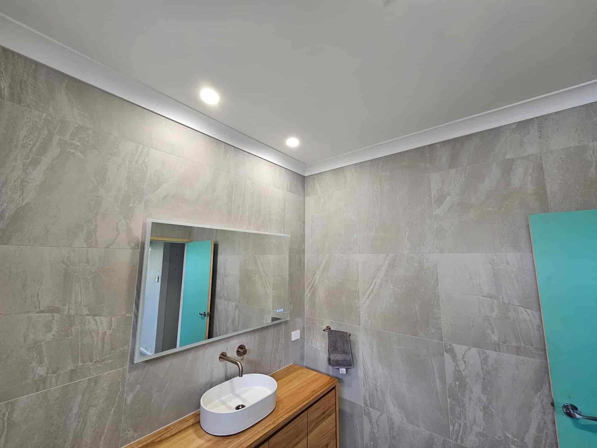 A Bathroom with A Sink, Mirror and Wooden Cabinet  — KPJ Electrical In Charlestown, NSW