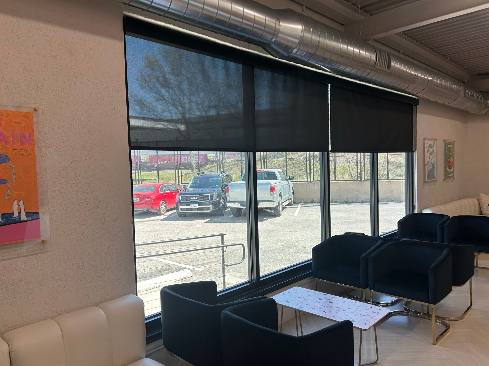A living room with a lot of windows and chairs and a table.