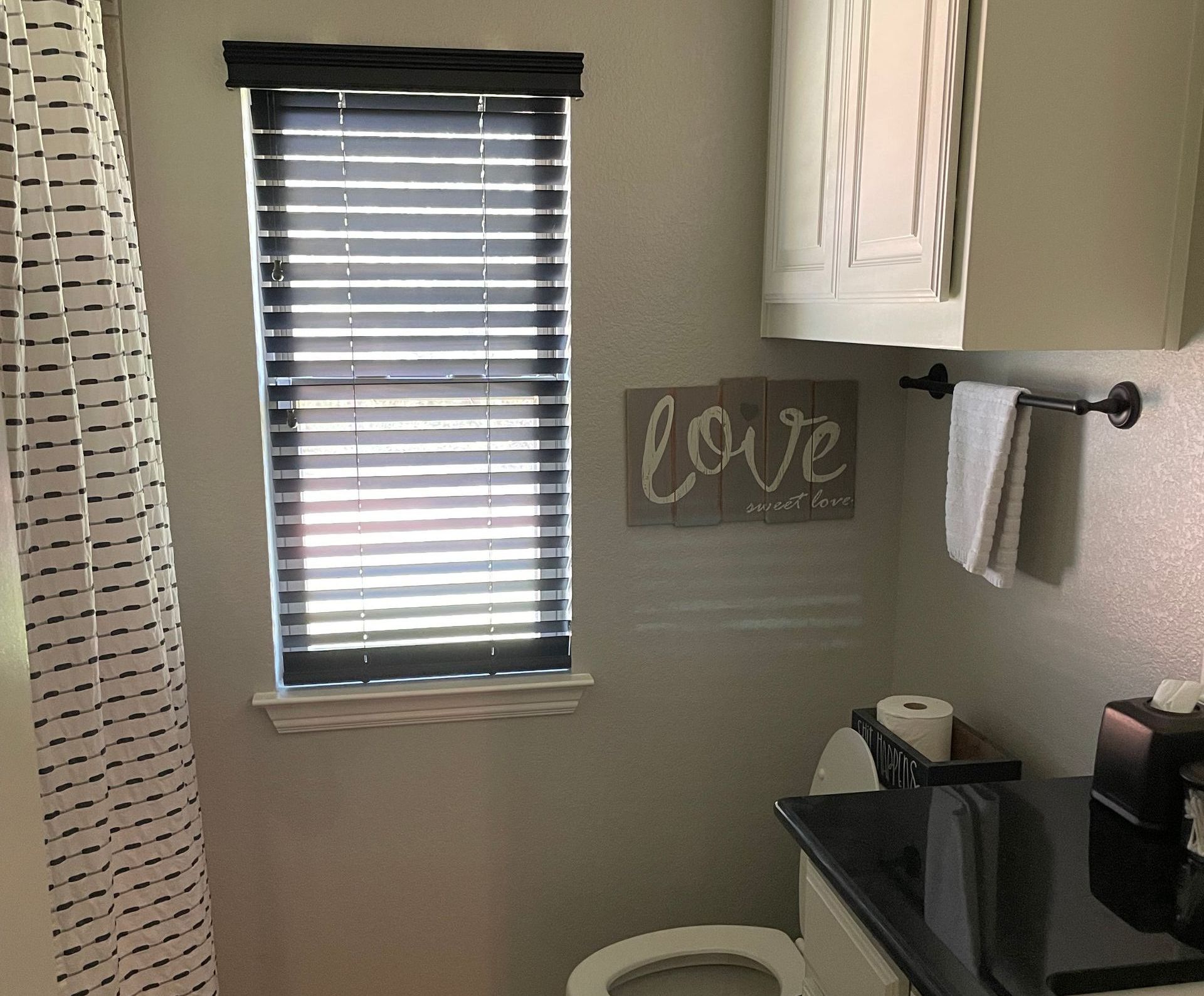 A bathroom with a sign on the wall that says love