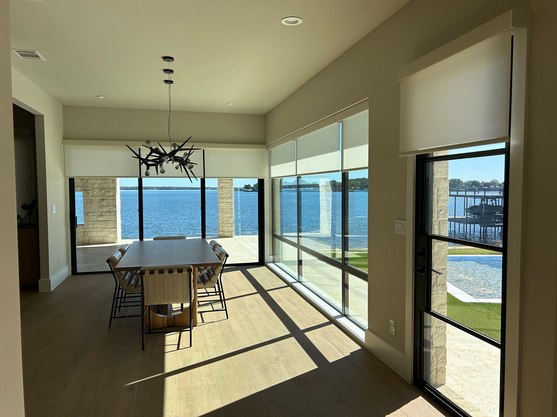 A dining room with a table and chairs and a view of the water.