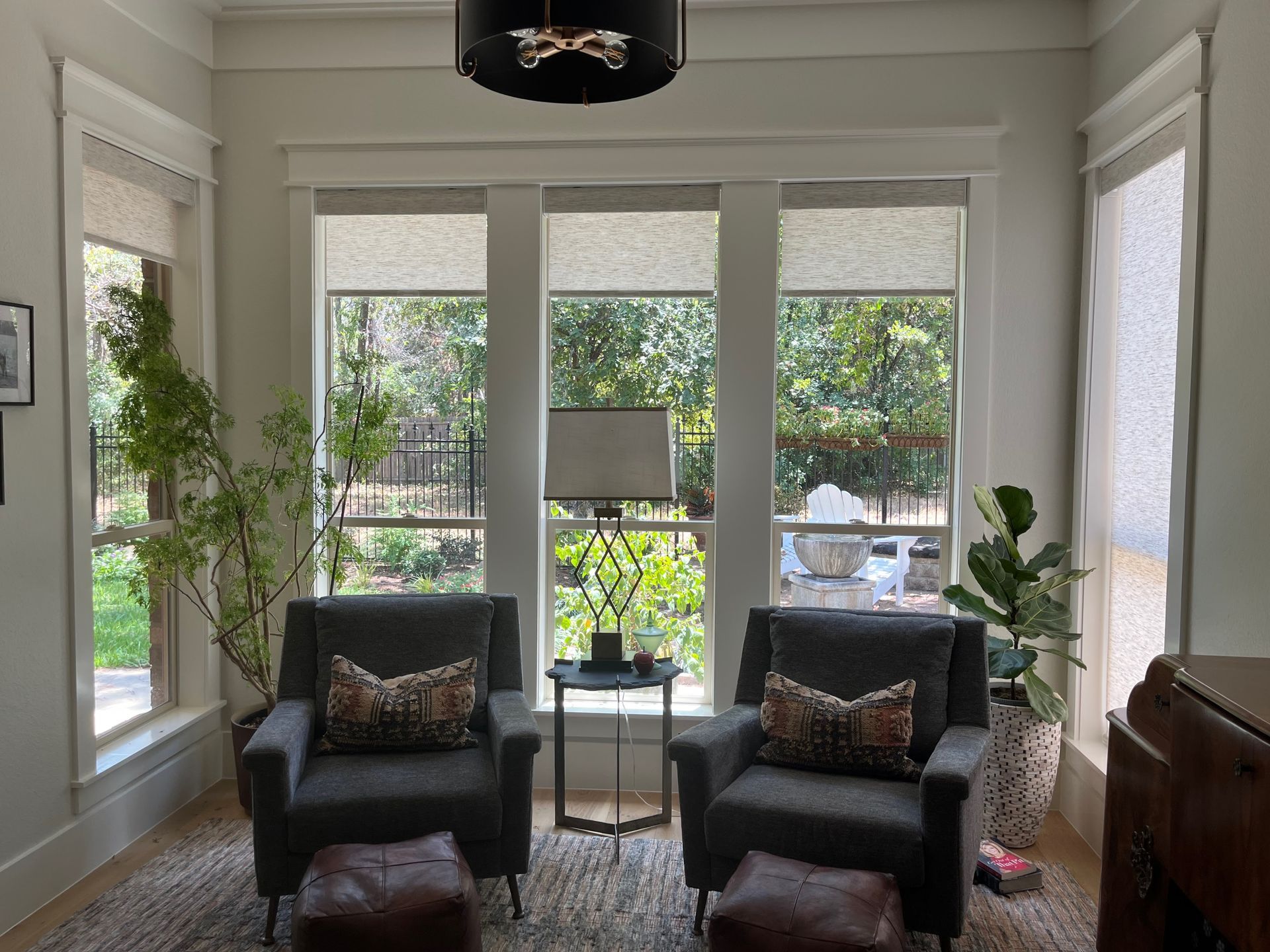 A living room with two chairs and two ottomans