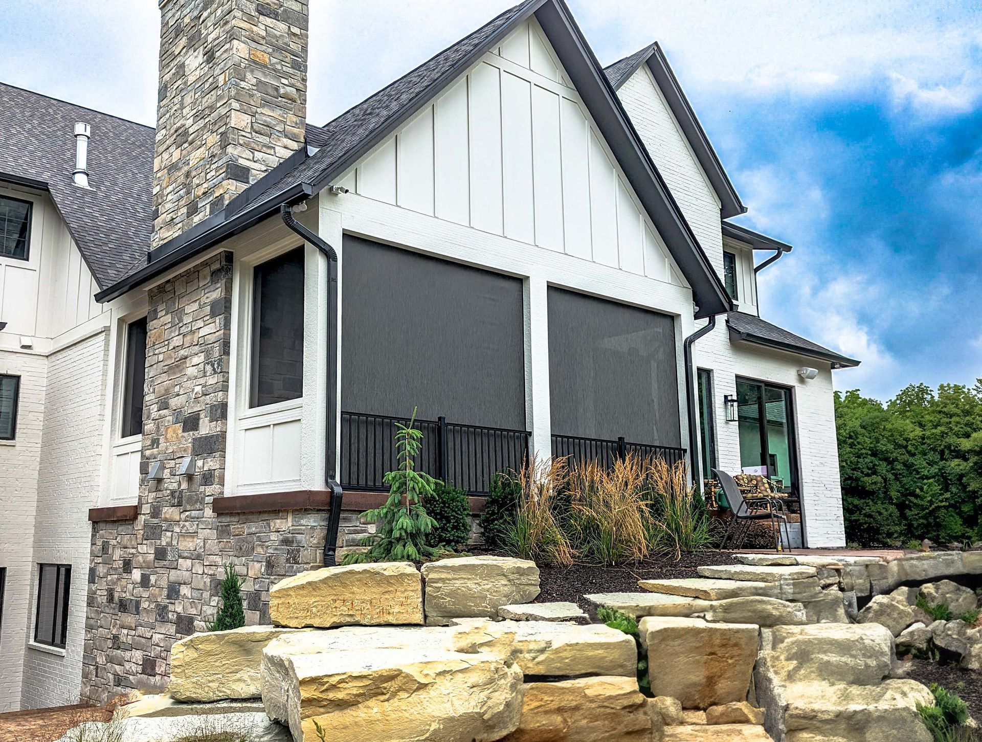 A large house with a screened in porch and stairs leading up to it.