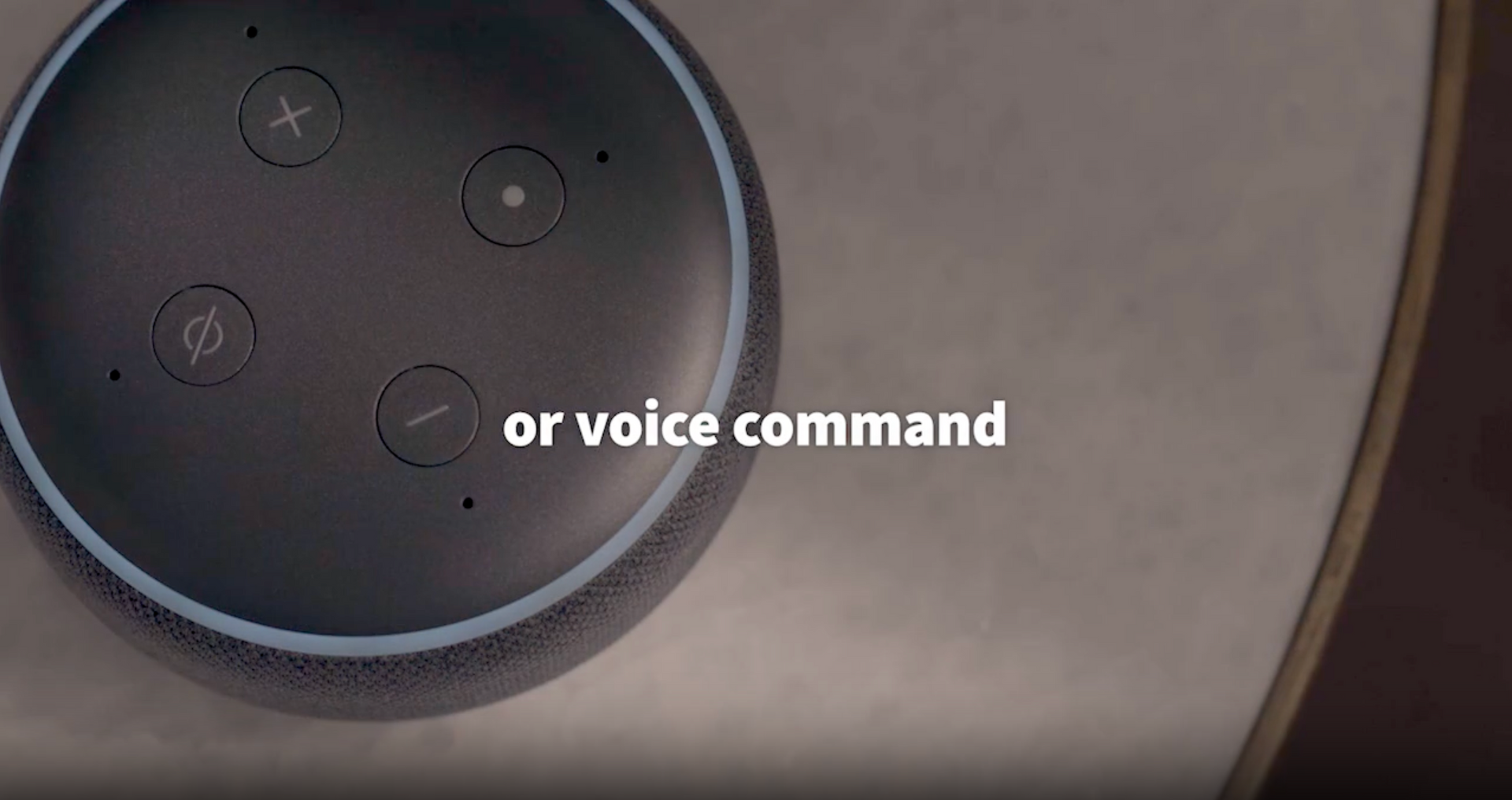 A close up of a voice command button on a smart speaker.