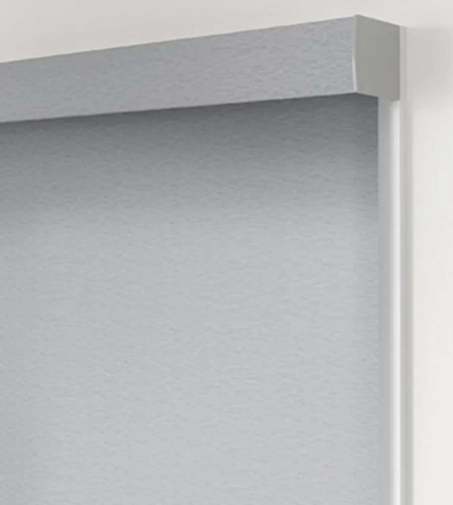A close up of a white roller blind on a window.