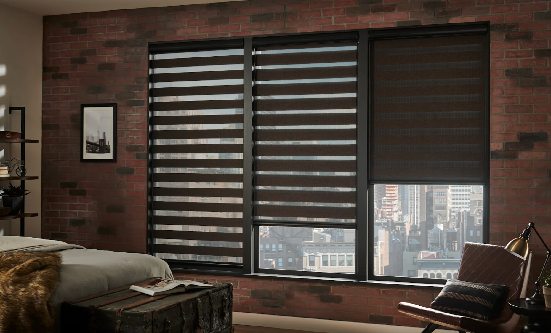 A bedroom with a brick wall , a bed , a chair , and a window with blinds.