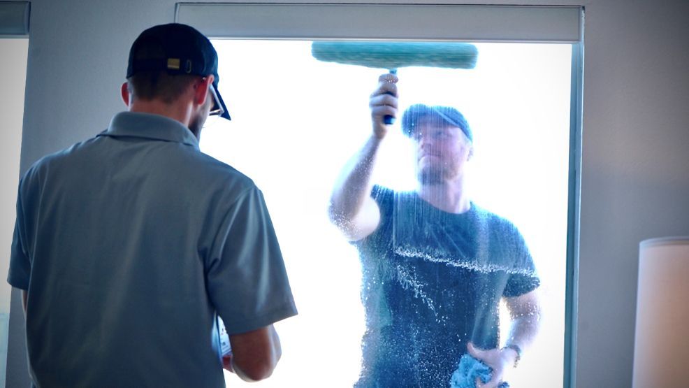 A man is cleaning a window with a squeegee.