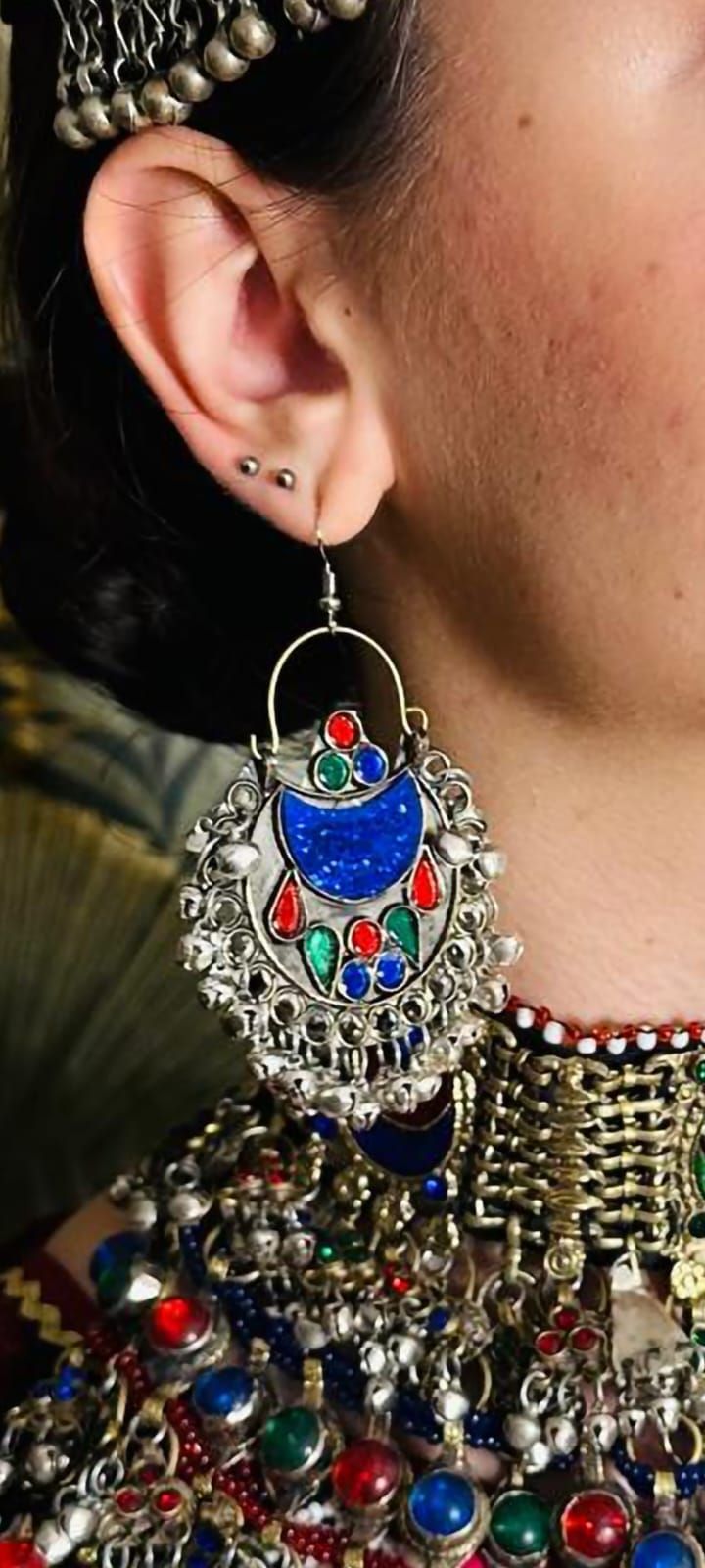 Eine Nahaufnahme einer Frau, die ein Paar Ohrringe trägt.